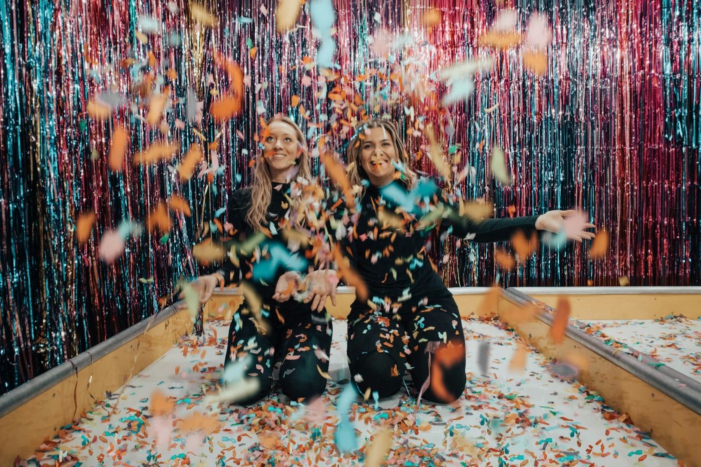 Twee vrouwen vieren feest tussen confetti