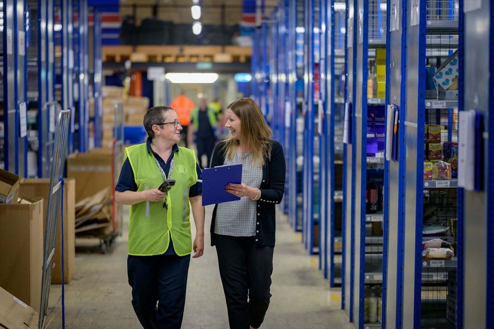 Twee collega's lopen door een magazijn